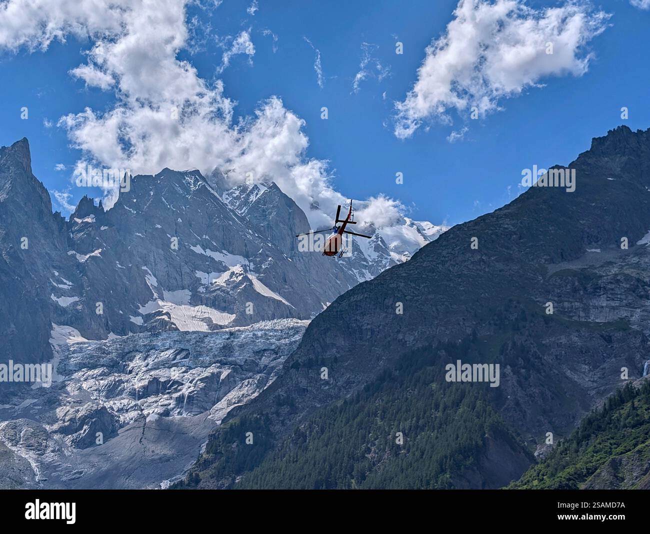 Un hélicoptère ambulance décolle pour une mission de sauvetage contre l'imposante toile de fond montagneuse des Alpes Banque D'Images