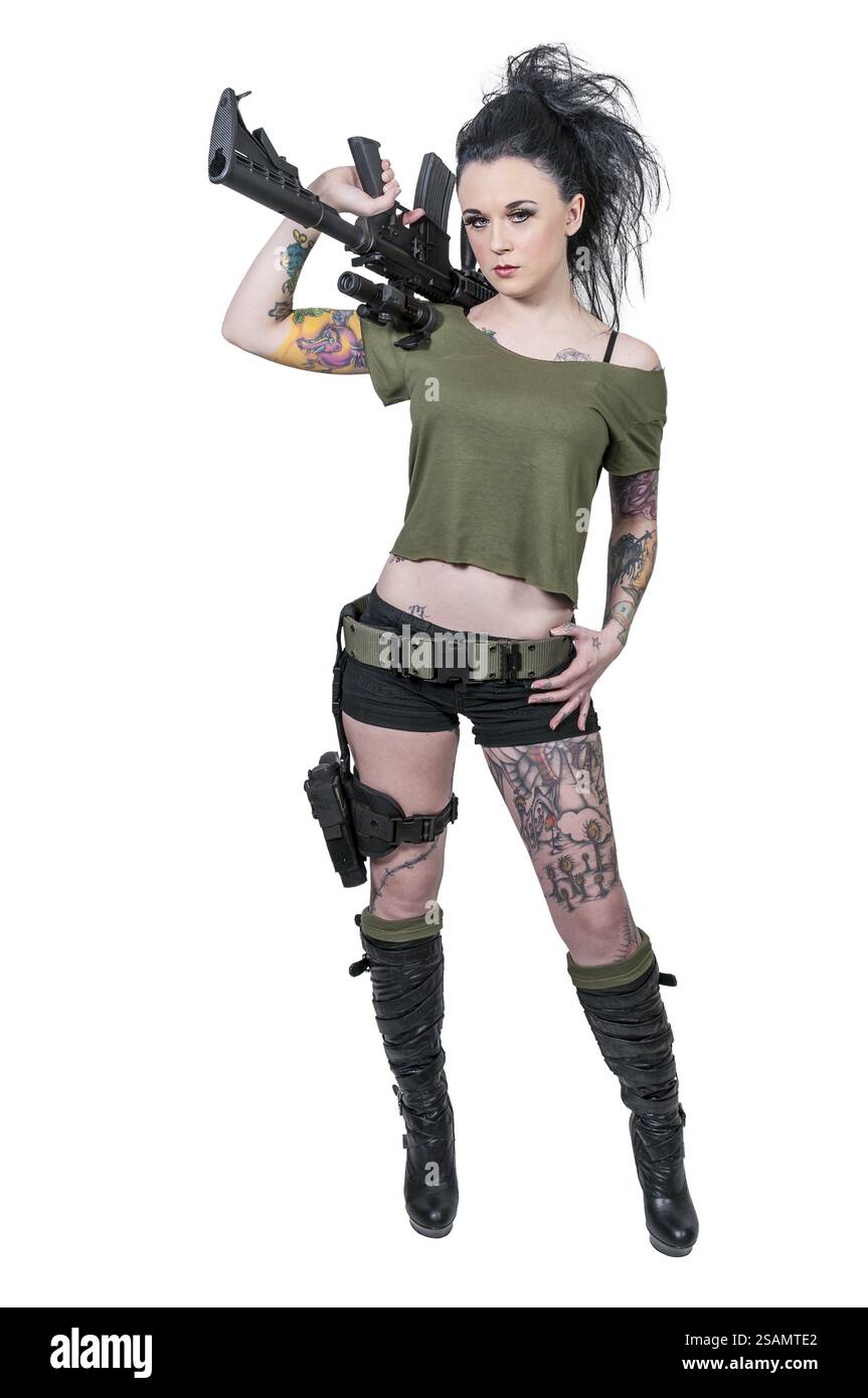 Belle jeune femme tatouée tenant un fusil d'assaut automatique Banque D'Images