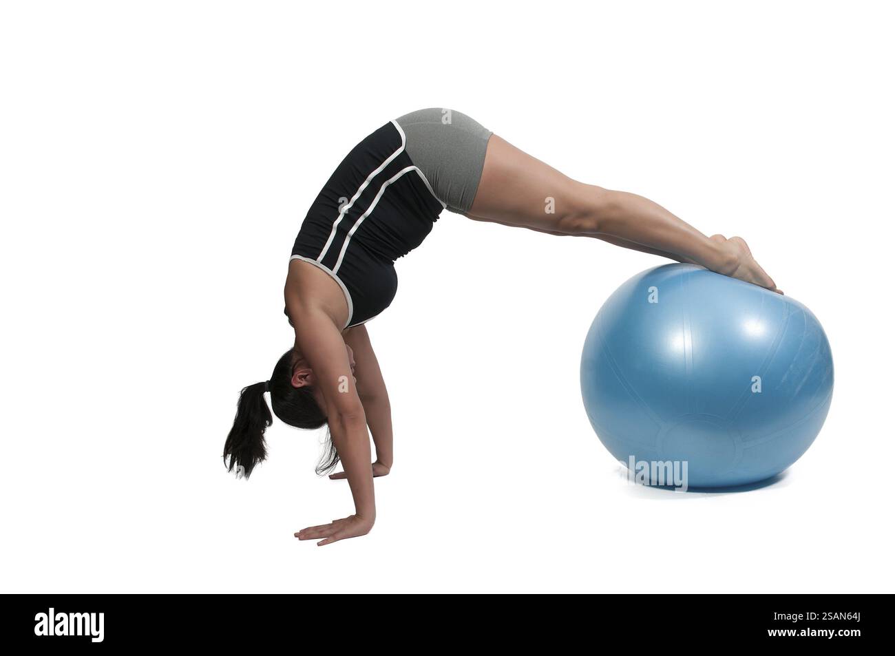 Belle jeune femme travaillant avec une boule d'exercice aérobie Banque D'Images