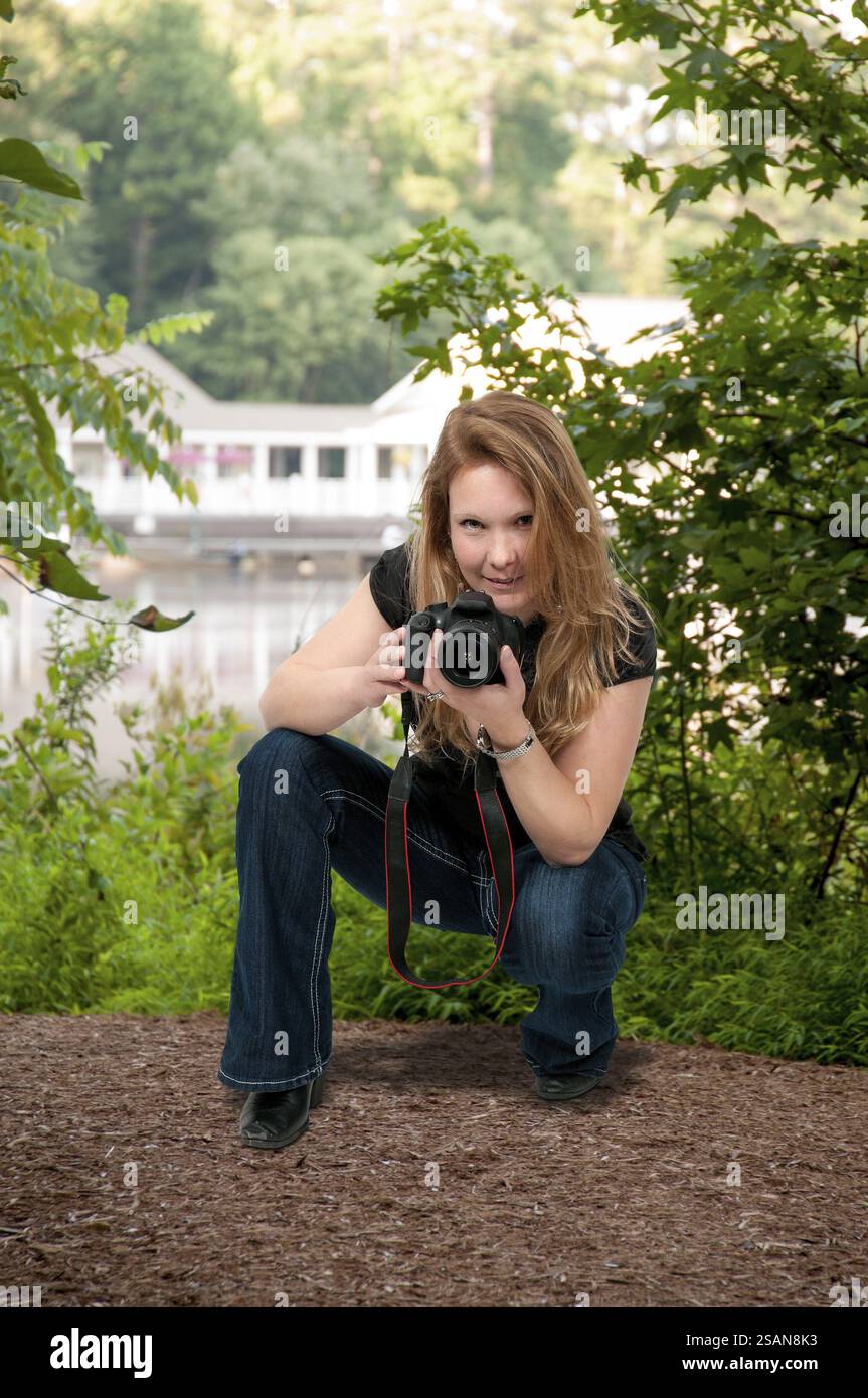 Femme utilisant un appareil photo reflex numérique à objectif unique Banque D'Images