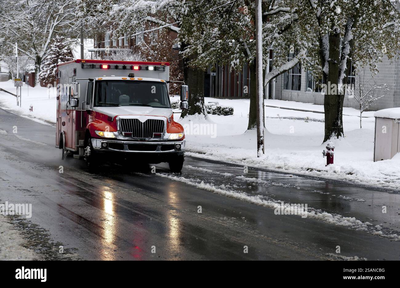 Une ambulance conduisant à une urgence un jour de neige Banque D'Images