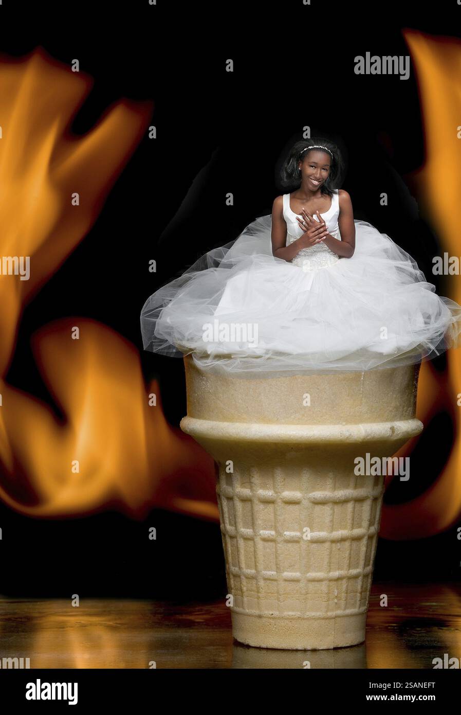 Belle jeune mariée dans une robe de mariée sur une crème glacée flamboyante dans un cône de gaufrette sur le feu Banque D'Images Belle jeune mariée dans une robe de mariée sur une crème glacée flamboyante dans un cône de gaufrette sur le feu Banque D'Images