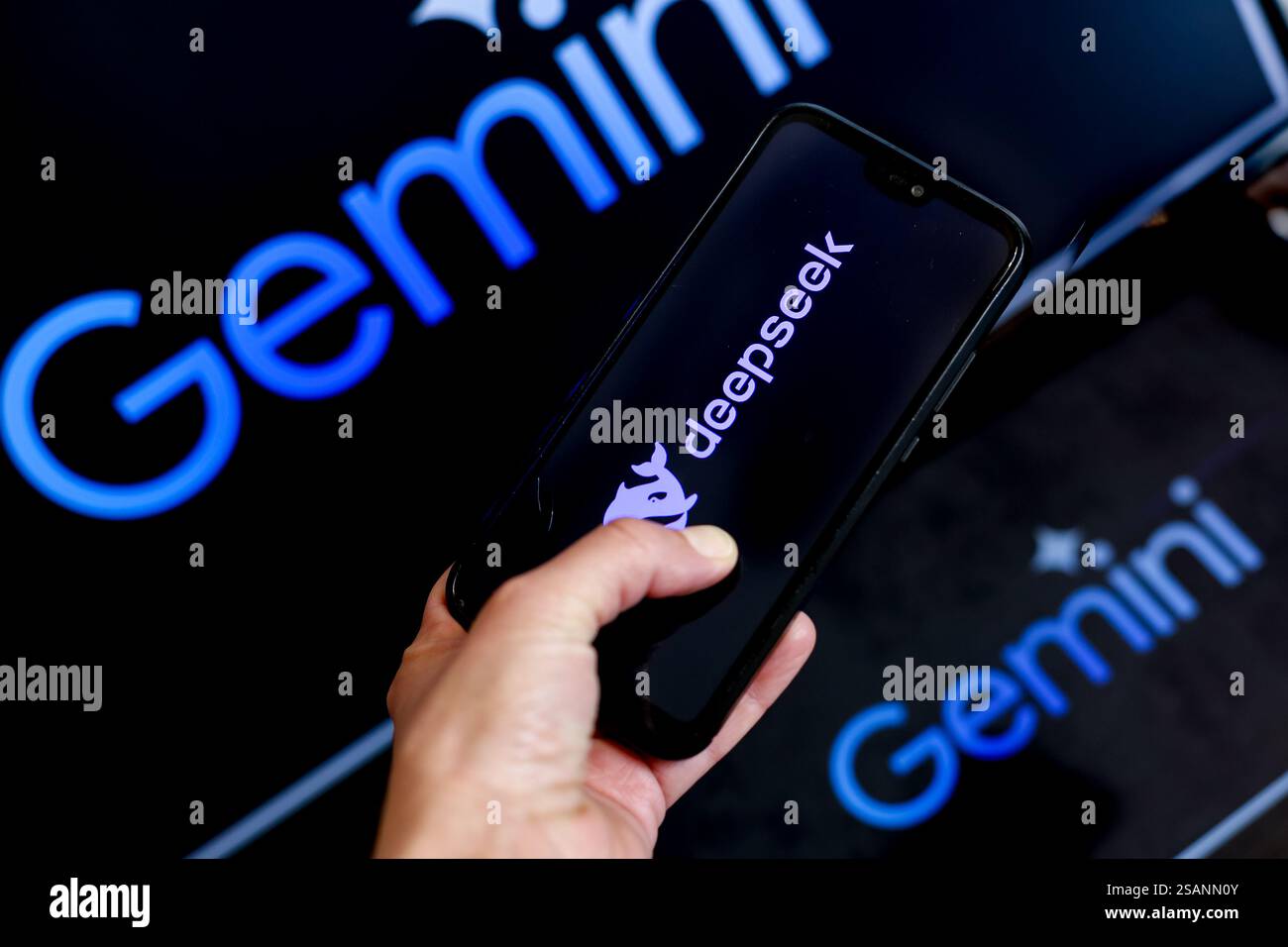 Dans cette illustration photo, le logo Gemini, A. I produit par Google, est montré sur deux écrans d'ordinateur contre le logo DeepSeek affiché sur un ph mobile Banque D'Images