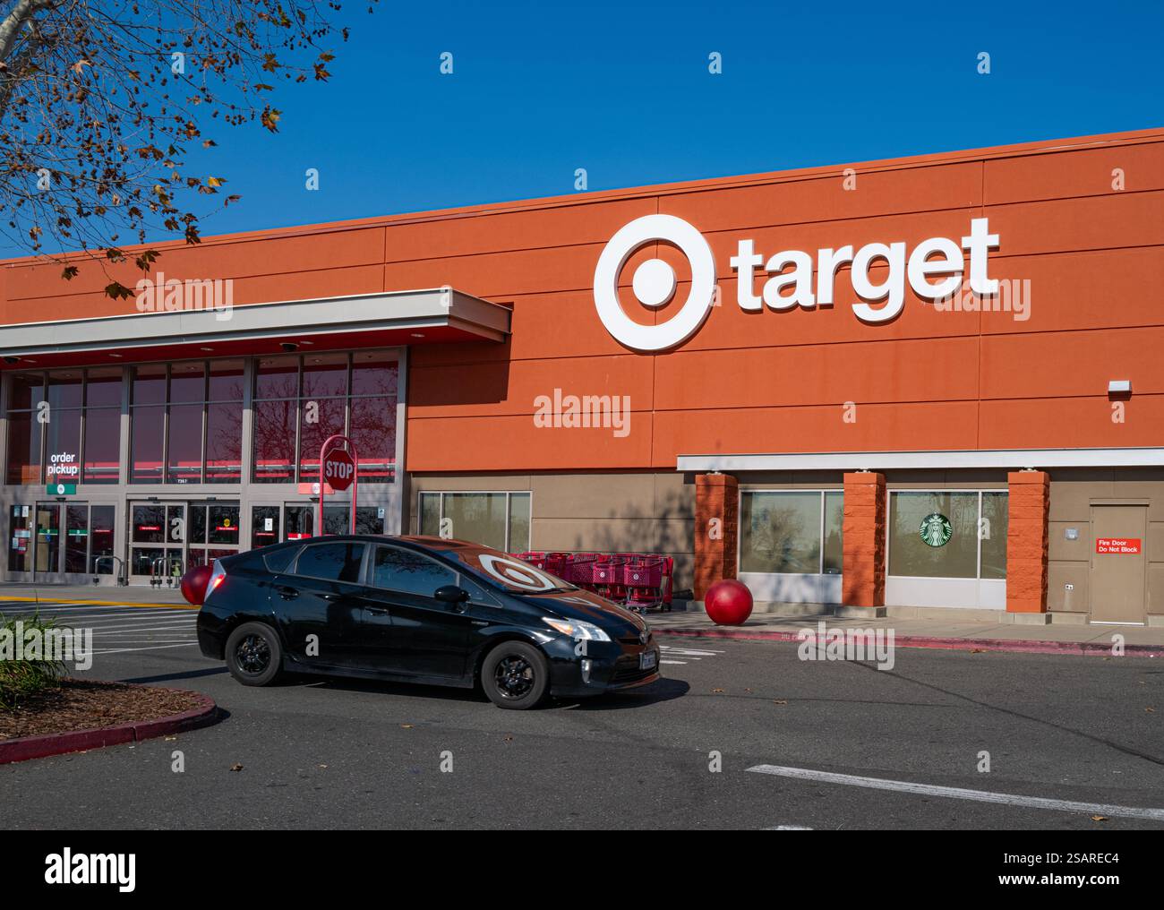 Devant un magasin Target avec voiture (et logo reflété). Des activistes réclament le boycott de Target après le retrait de ses initiatives DEI. Banque D'Images