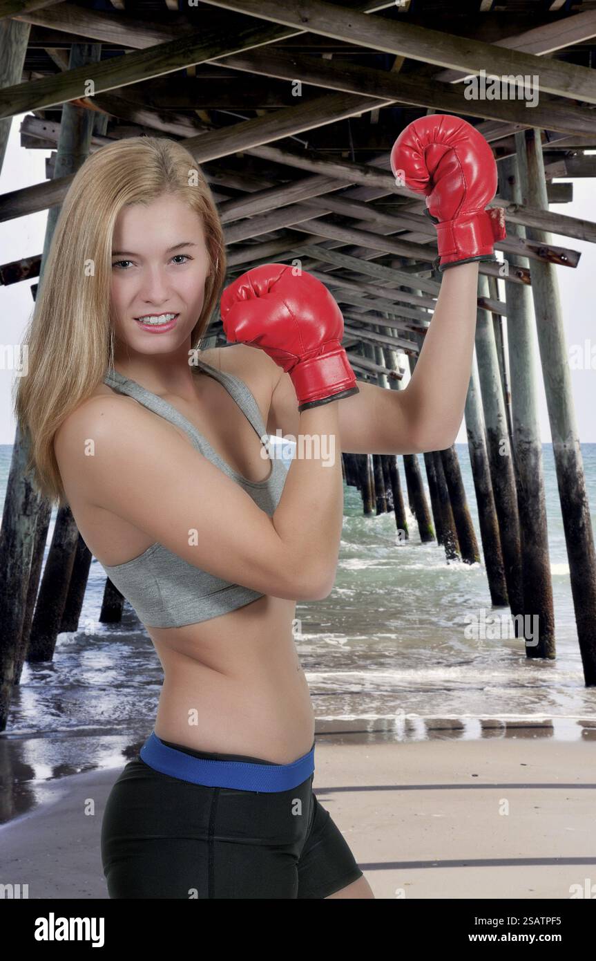 Une belle jeune femme portant une paire de gants de boxe Banque D'Images