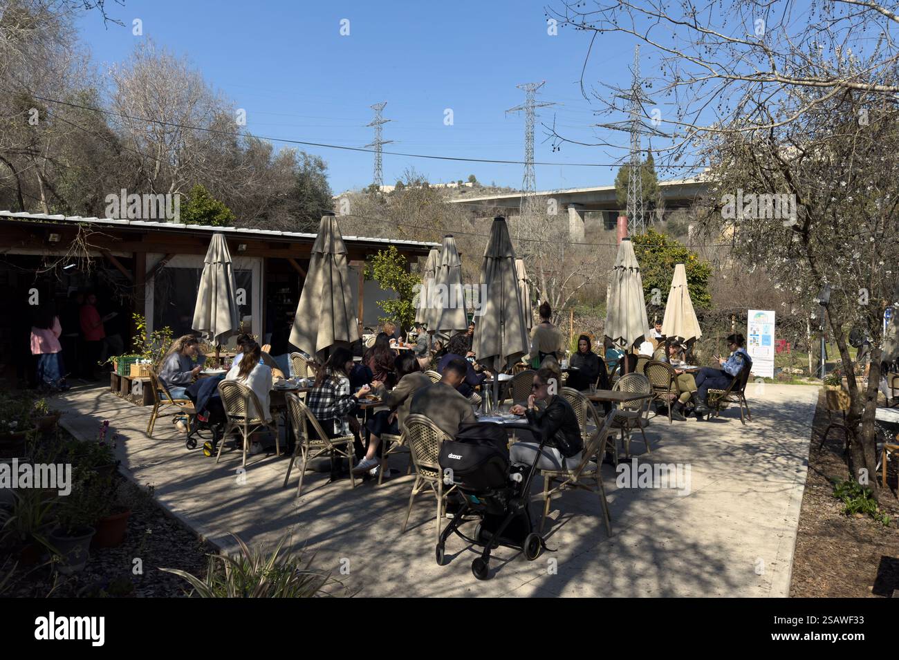 Les gens sont assis dans le café Alloro situé dans la cour de Beit Yalin, la première maison construite par des Juifs dans une vallée de Jérusalem, qui sera plus tard appelée Emek Motza, un quartier à l'ouest de Jérusalem, en Israël. Banque D'Images
