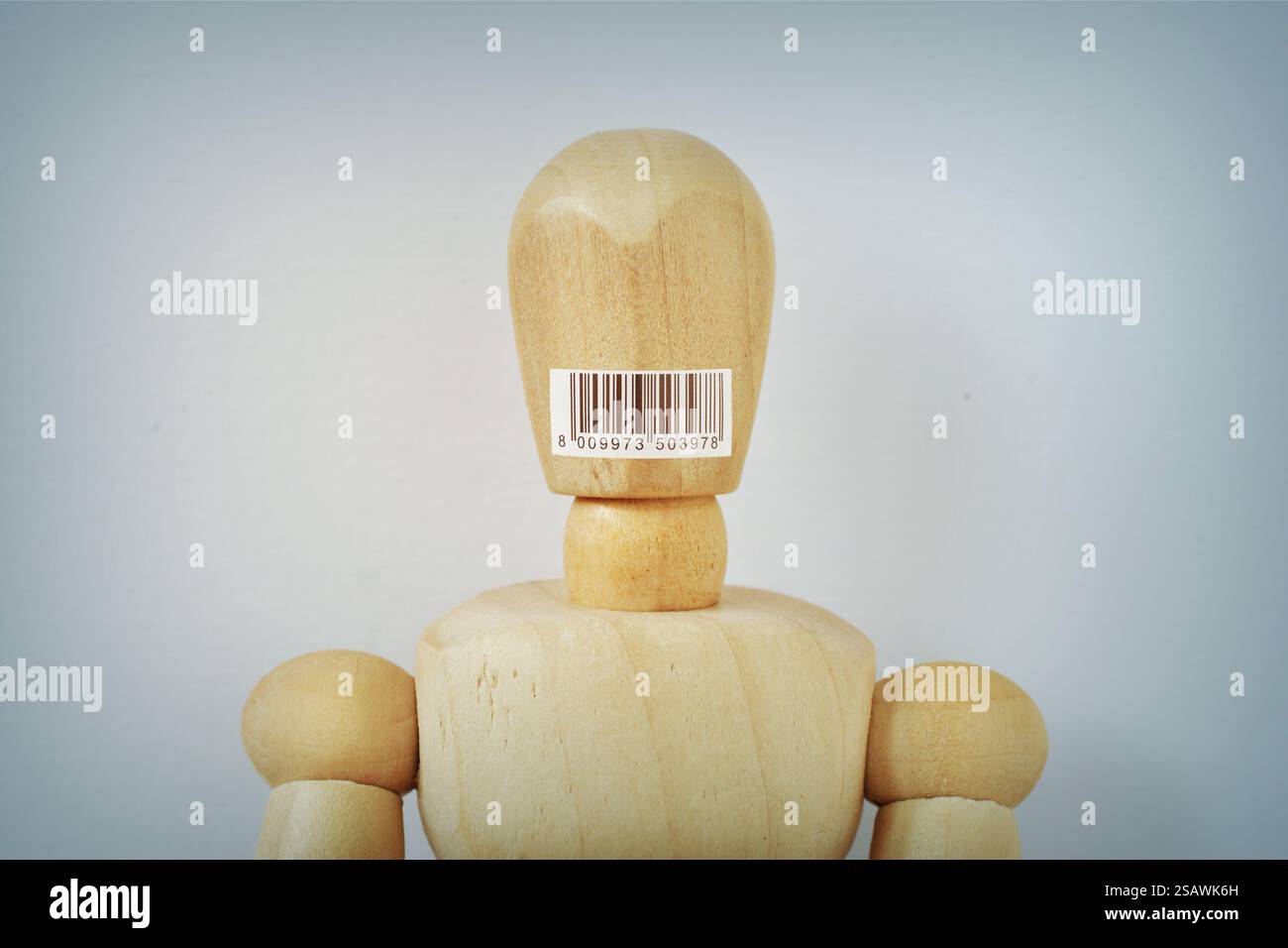 Mannequin en bois avec code à barres sur sa bouche - concept de consumérisme et d'esclavage Banque D'Images