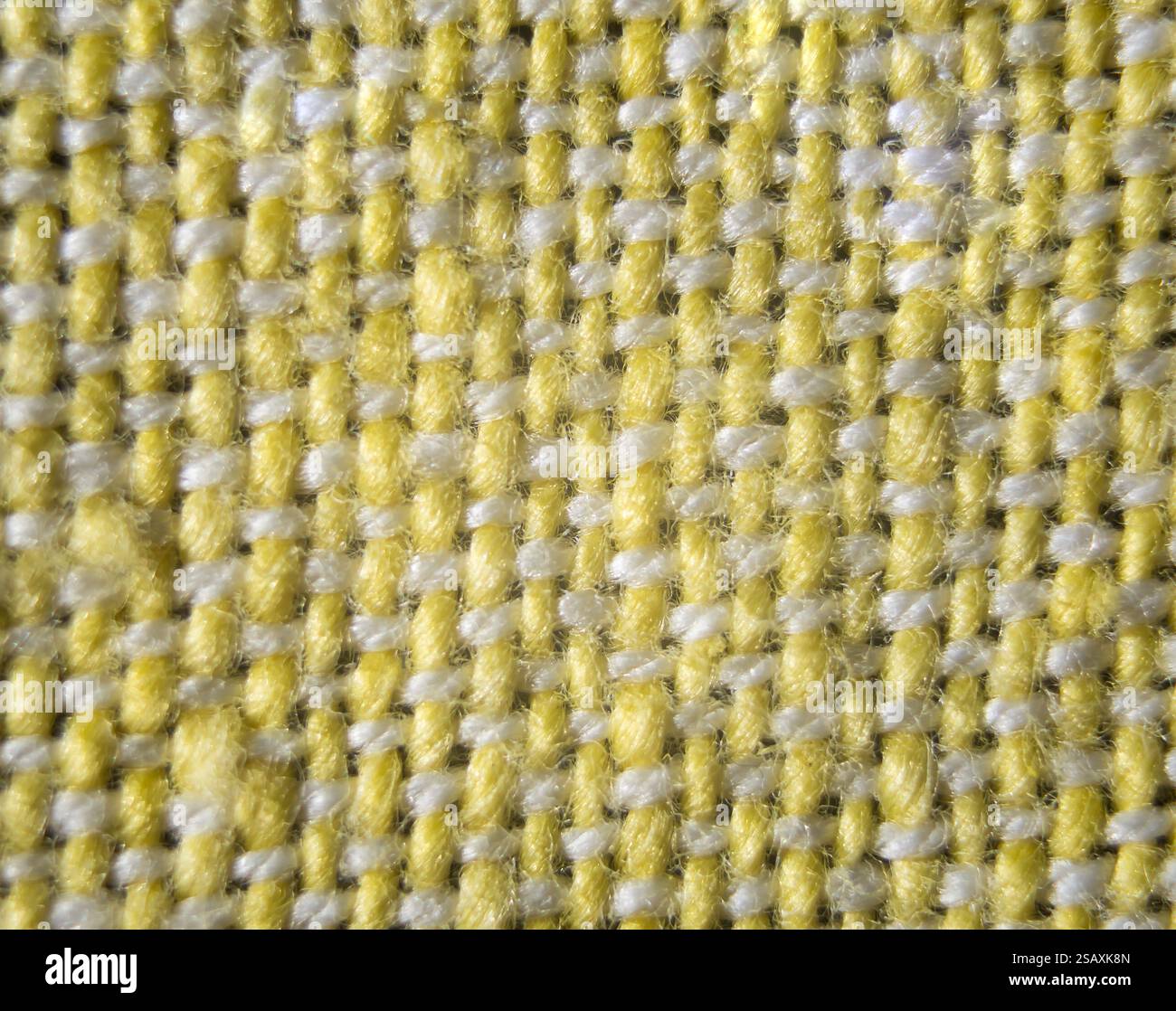 Texture détaillée d'un tissu tissé avec un motif sans couture en jaune vif et gris subtil, idéal pour diverses applications de conception. Banque D'Images