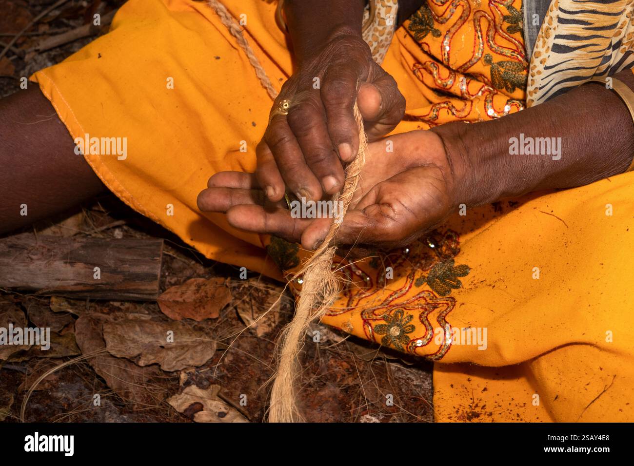 Afrique Tanzanie, Zanzibar, Côte est, Jambiani, visite culturelle du village, femme roulant pilées séchées, fibres de coque de noix de coco pour faire de la corde Banque D'Images