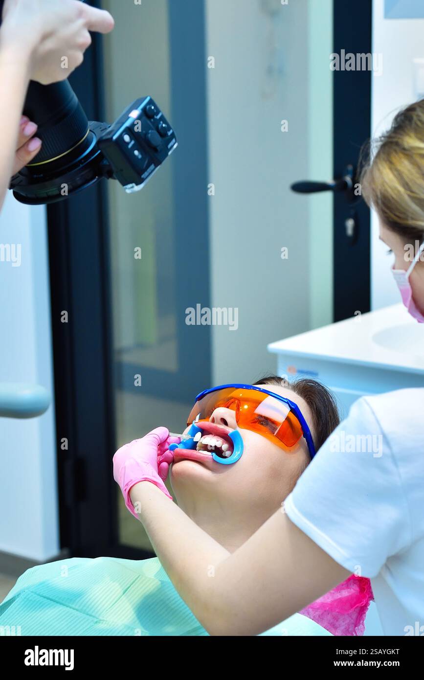 Le dentiste tire-t-il des teintes avant la procédure de blanchiment. Concept de blanchiment dentaire et dentaire. Banque D'Images Le dentiste tire-t-il des teintes avant la procédure de blanchiment. Concept de blanchiment dentaire et dentaire. Banque D'Images