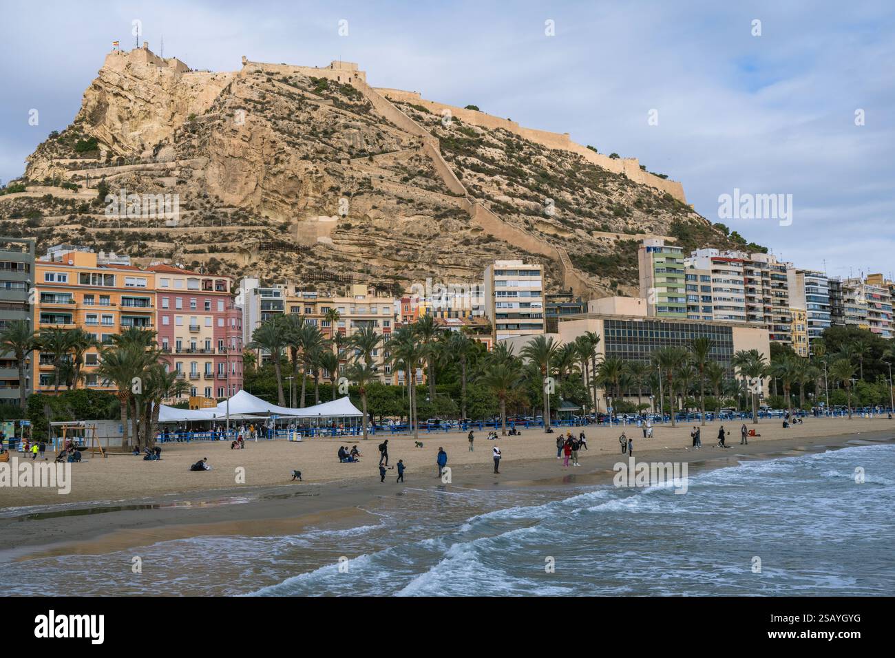 Ceci est une vue sur la plage d'Alicante et le front de mer avec la colline du château de Santa Bárbara au loin le 20 janvier 2024 à Alicante, Espagne Banque D'Images