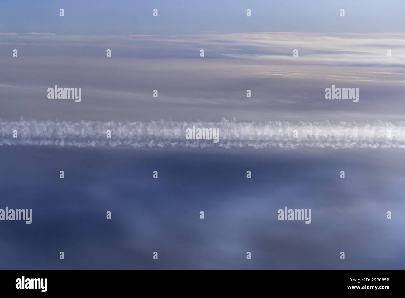Vue sur le golfe Persique depuis la fenêtre de l'avion. Soleil et nuages au-dessus de la mer. Avion au-dessus des nuages avec des traînées de vapeur. Vol avec l'airlin Banque D'Images