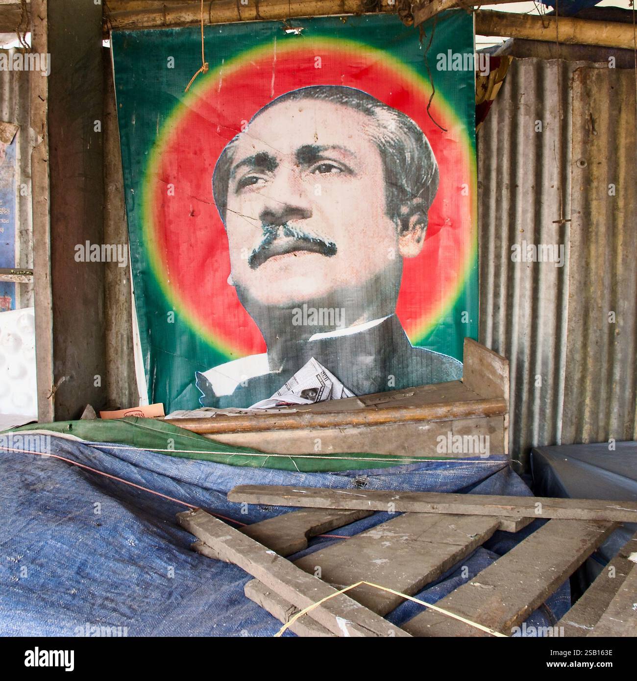 Une affiche altérée du cheikh Mujibur Rahman, le dirigeant fondateur du Bangladesh, exposée à l’intérieur d’un étal rustique du marché de Dhaka. Banque D'Images