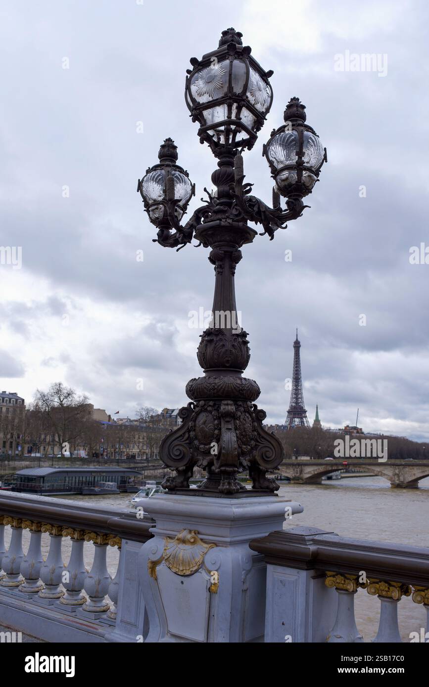 Lampes Art Nouveau sur le Pont Alexandre III, (pont Alexandre) avec en arrière-plan la Tour Eiffel par un jour nuageux d'hiver Banque D'Images