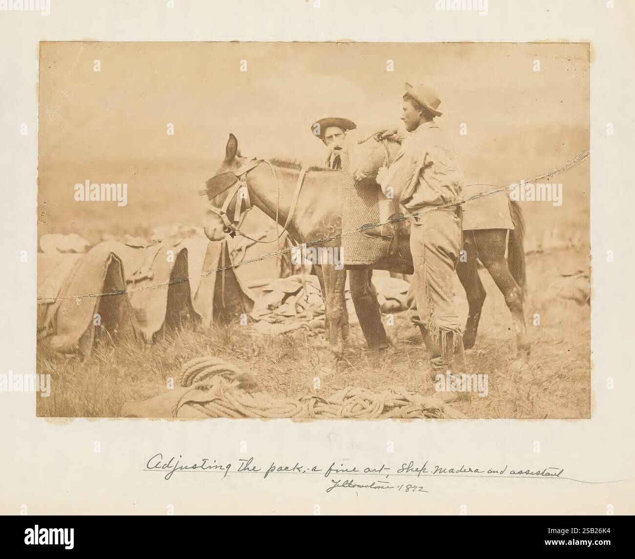 Aléatoire, enregistrements, de, a, durée de vie, 1846-1931, [en fait 1932]., deux individus se tiennent ensemble dans un milieu rural, entourés de grandes piles de matériaux récoltés, peut-être du foin ou du grain. Une personne tient une fourche tandis que l'autre pose avec confiance les bras croisés. Ils sont tous les deux habillés dans une tenue de travail appropriée pour les tâches agricoles. En arrière-plan, des champs étendus s'étendent, indiquant un paysage agricole. Il y a une note manuscrite dans le coin qui date la scène à 1892, suggérant un moment capturé au plus fort des activités agricoles à cette époque. Le o Banque D'Images