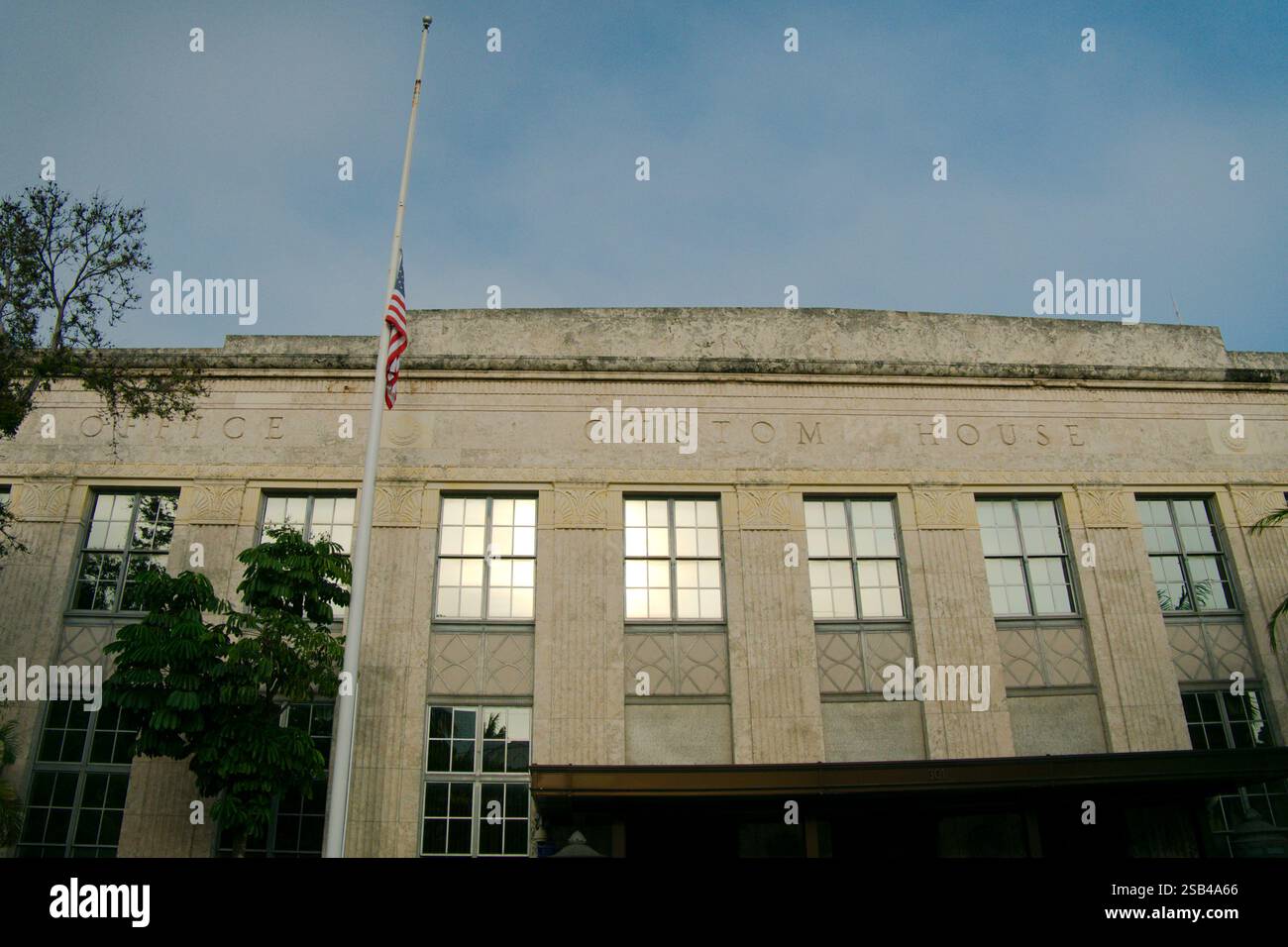 Vue large sur le bâtiment de la douane américaine. Usage éditorial uniquement 21 janvier 2025, Key West, Floride, États-Unis. Drapeau américain en Berne avec un ciel bleu. Banque D'Images