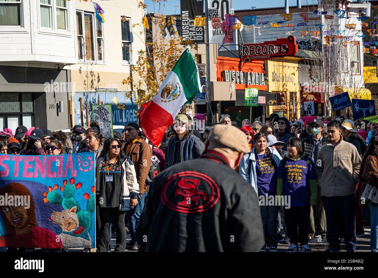Une foule avec le drapeau mexicain attend pour commencer à marcher lors de la marche du jour de la résistance deux jours avant l'investiture du président Trump. Banque D'Images