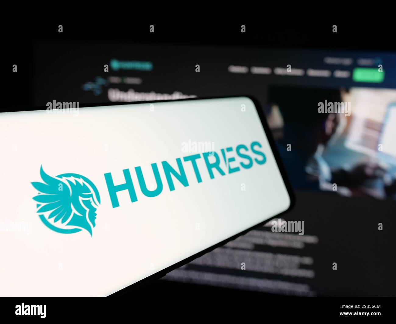 Dans cette illustration photo, un téléphone portable avec le logo de la société américaine de cybersécurité Huntress Labs Inc est vu sur l'écran devant le site Web de l'entreprise. Banque D'Images