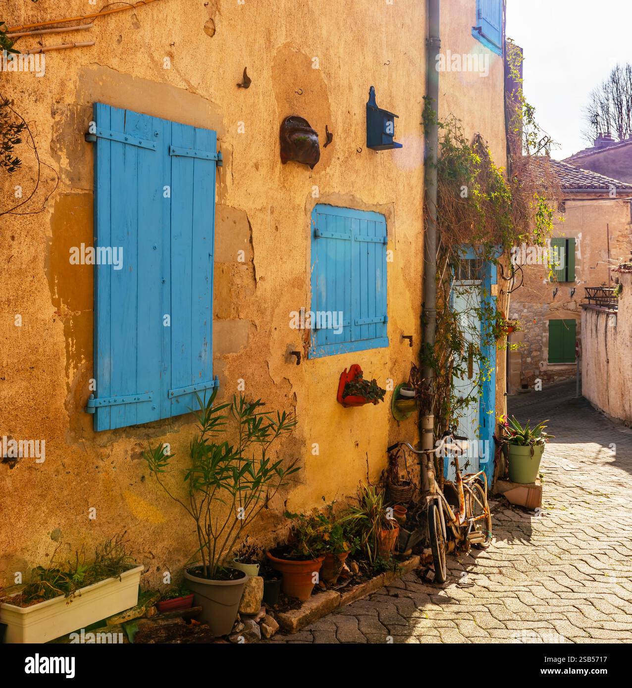 Vélo contre le mur jaune d'une maison, dans le village de Lautrec, dans le Tarn, Occitanie, France Banque D'Images
