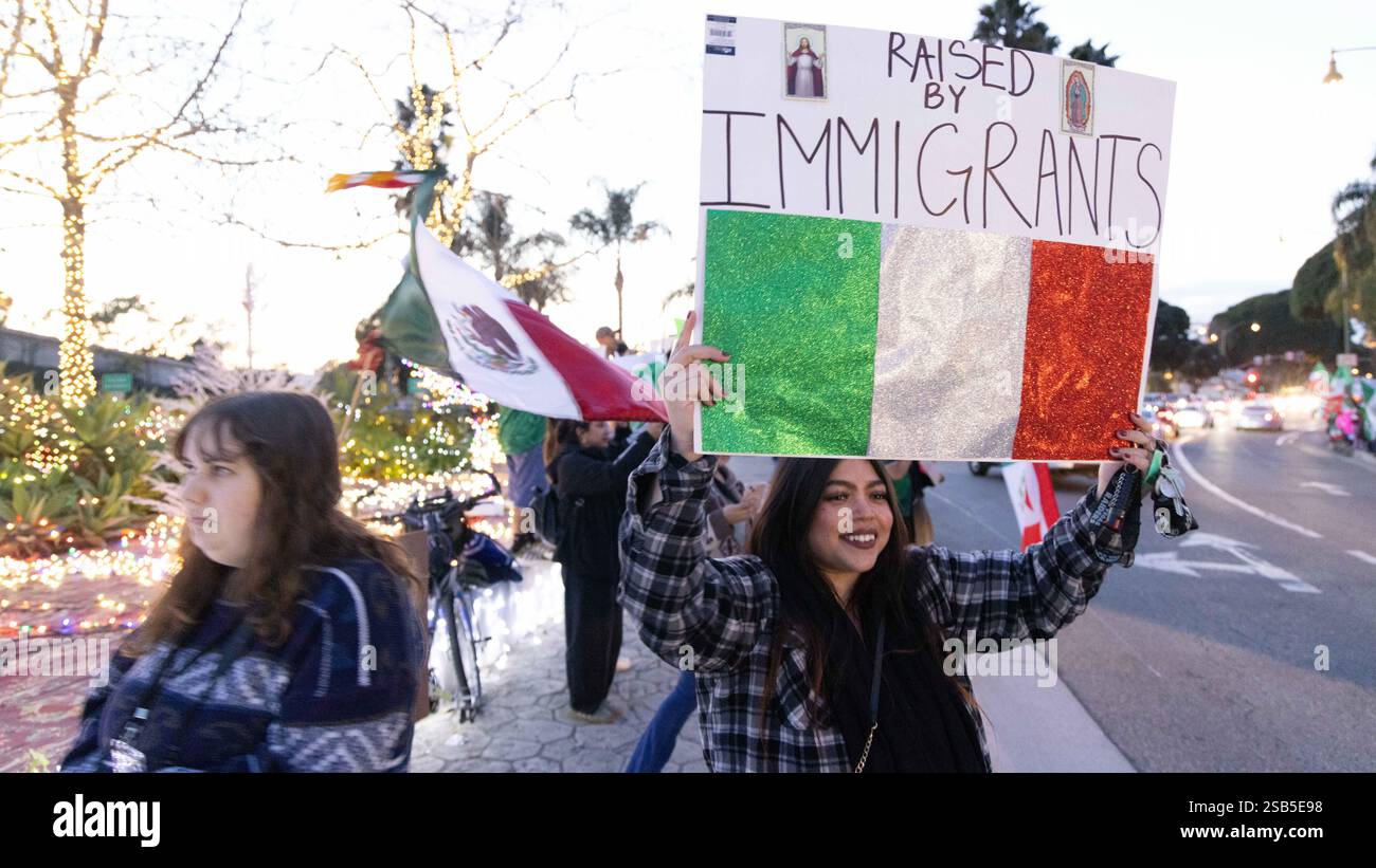 Sanra Barbara, Californie, États-Unis. 31 janvier 2025. Une femme mexicaine-américaine souriante tient un panneau, 'élevé par des immigrants'' alors que plus de 500 manifestants ''' la plupart d'entre eux sont des enfants d'immigrants ou d'immigrants eux-mêmes ''' se sont rassemblés dans le Lower East Side de Santa Barbara, pour protester contre les arrestations DE GLACE et les politiques agressives d'immigration du président Trump. Ce qui était prévu comme un petit rassemblement s'est transformé en un rassemblement de masse. Crédit : ZUMA Press, Inc/Alamy Live News Banque D'Images