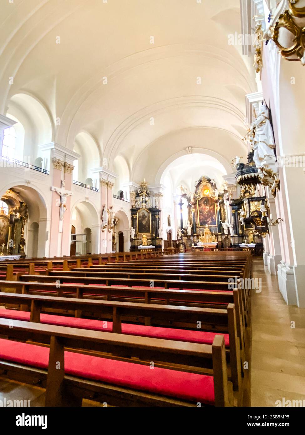L'église est vide et les bancs sont rouges. L'intérieur est très grand et les arches sont très hautes Banque D'Images