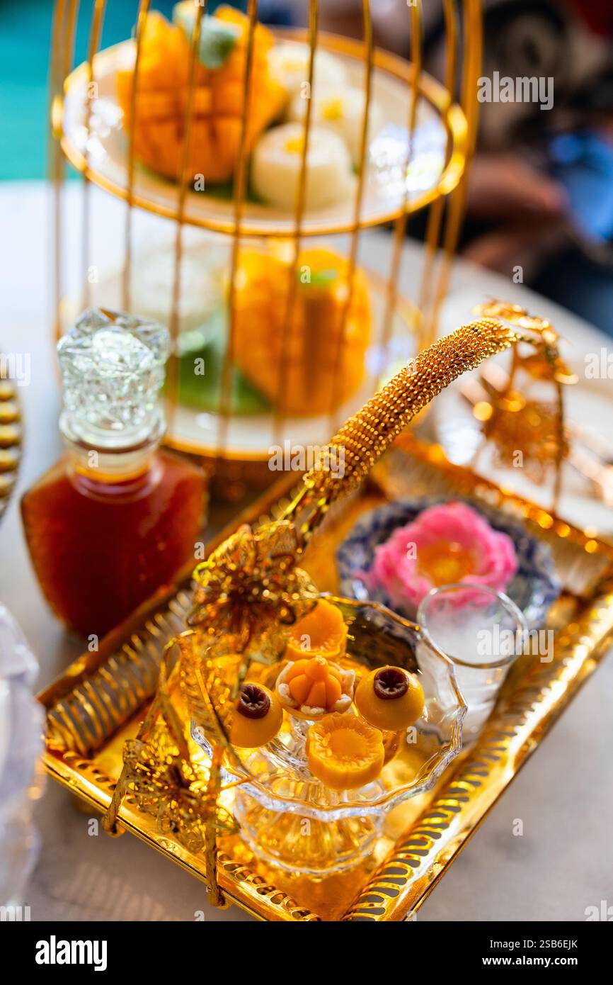 Une présentation élégante de desserts traditionnels dans un plateau doré aux détails complexes Banque D'Images