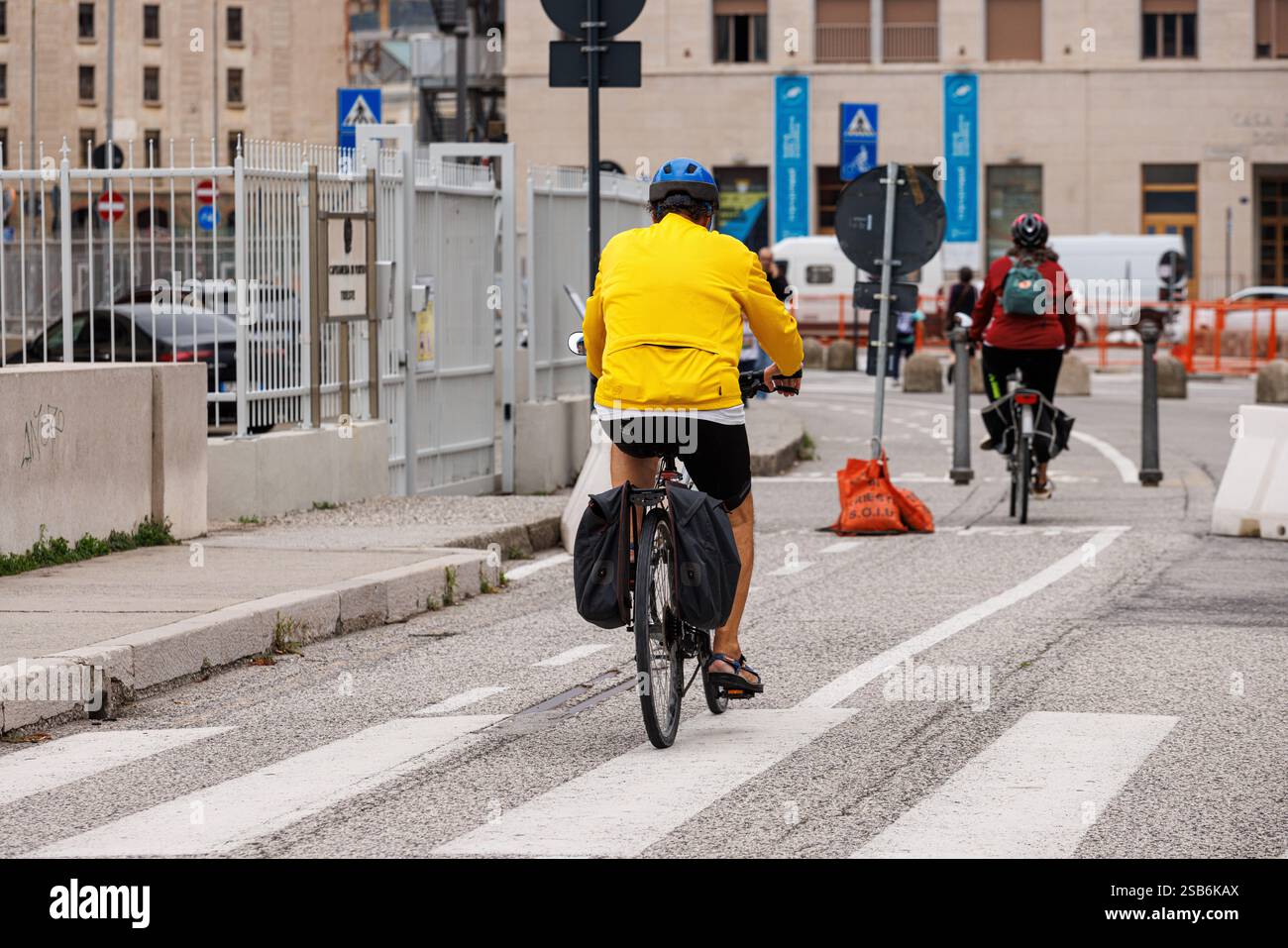 Trieste, Italie - 27 septembre 2024 : vue arrière d'un cycliste occasionnel dans la circulation urbaine utilisant la piste cyclable, Trieste. Italie Banque D'Images Trieste, Italie - 27 septembre 2024 : vue arrière d'un cycliste occasionnel dans la circulation urbaine utilisant la piste cyclable, Trieste. Italie Banque D'Images