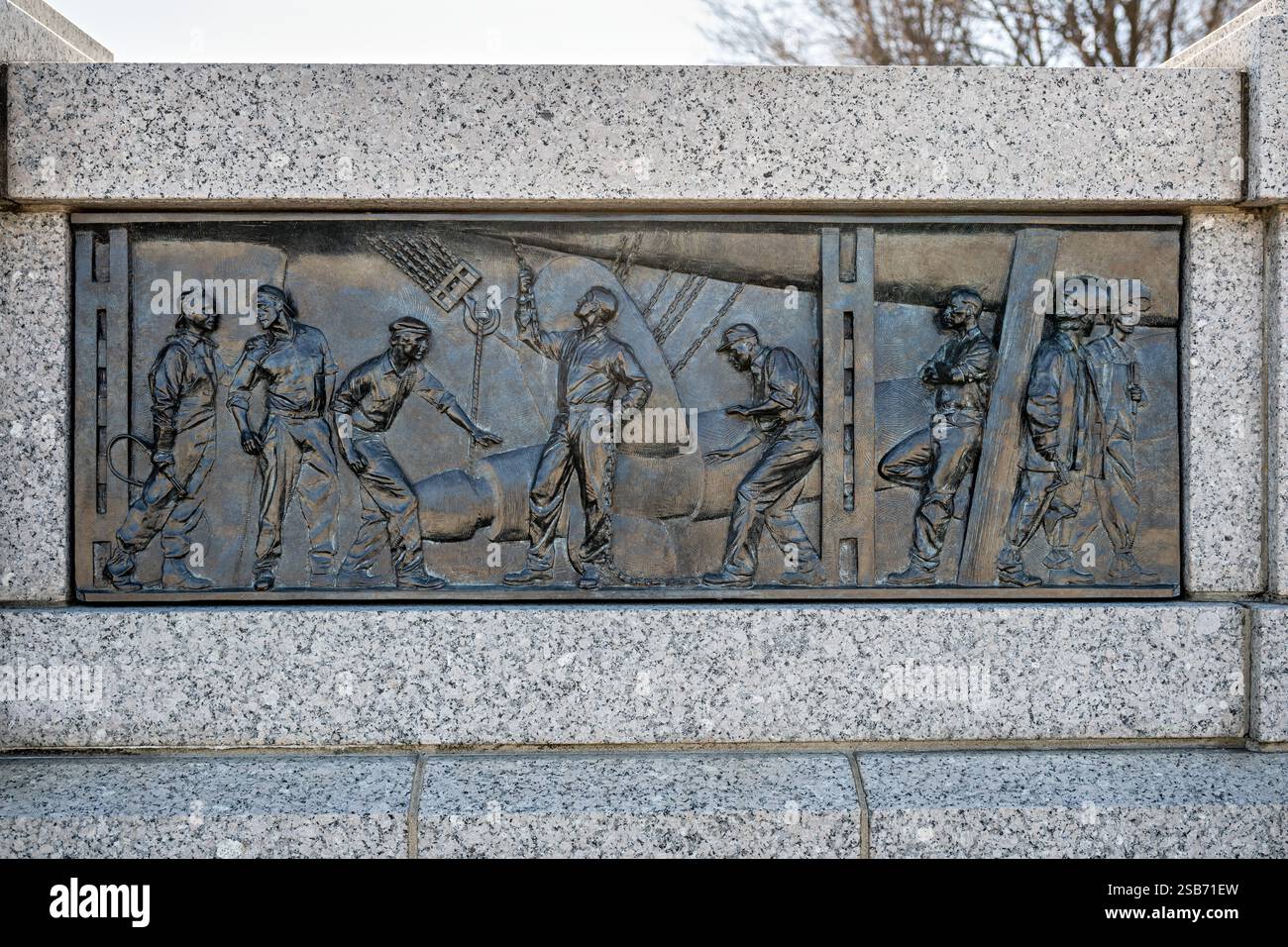 WASHINGTON DC — le bas-relief en bronze « Ship Building » au National World War II Memorial représente la production des chantiers navals américains pendant la guerre, illustrant la politique du président Franklin Roosevelt de prêter du matériel de guerre aux alliés et l'augmentation de la construction de navires de transport et de navires de guerre après l'attaque de Pearl Harbor. Créée par le sculpteur Ray Kaskey, cette œuvre d'art est l'un des 24 bas-reliefs en bronze situés le long de l'entrée cérémonielle du mémorial qui représentent à la fois le front de maison et des scènes de bataille de la guerre. Le bas-relief fait partie de la section Pacific Theater sur le côté sud de l'entr Banque D'Images