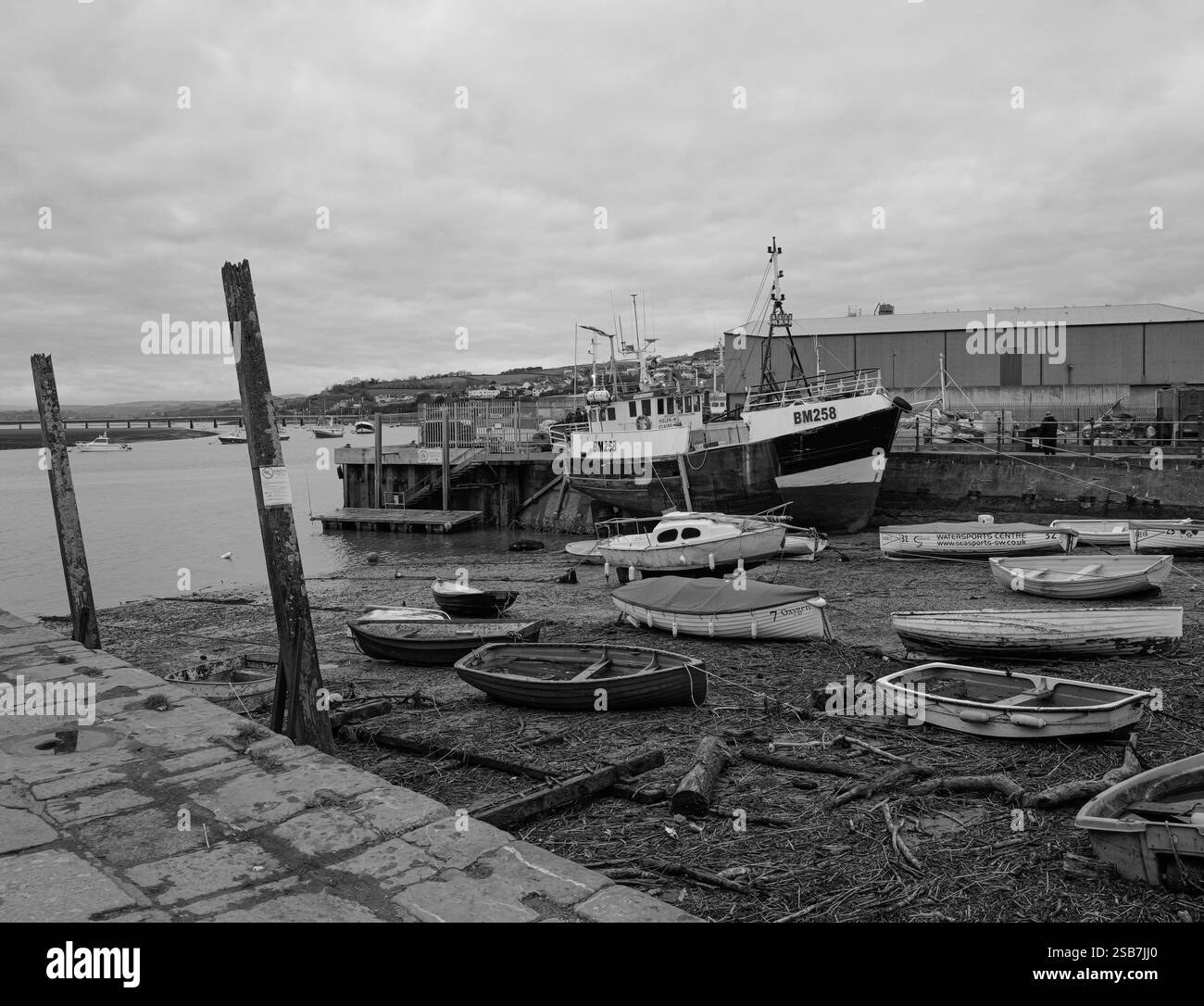Un chalutier à quai pour des réparations au quai de pêche à Teignmouth, Devon, Royaume-Uni. Photographie en noir et blanc. Banque D'Images