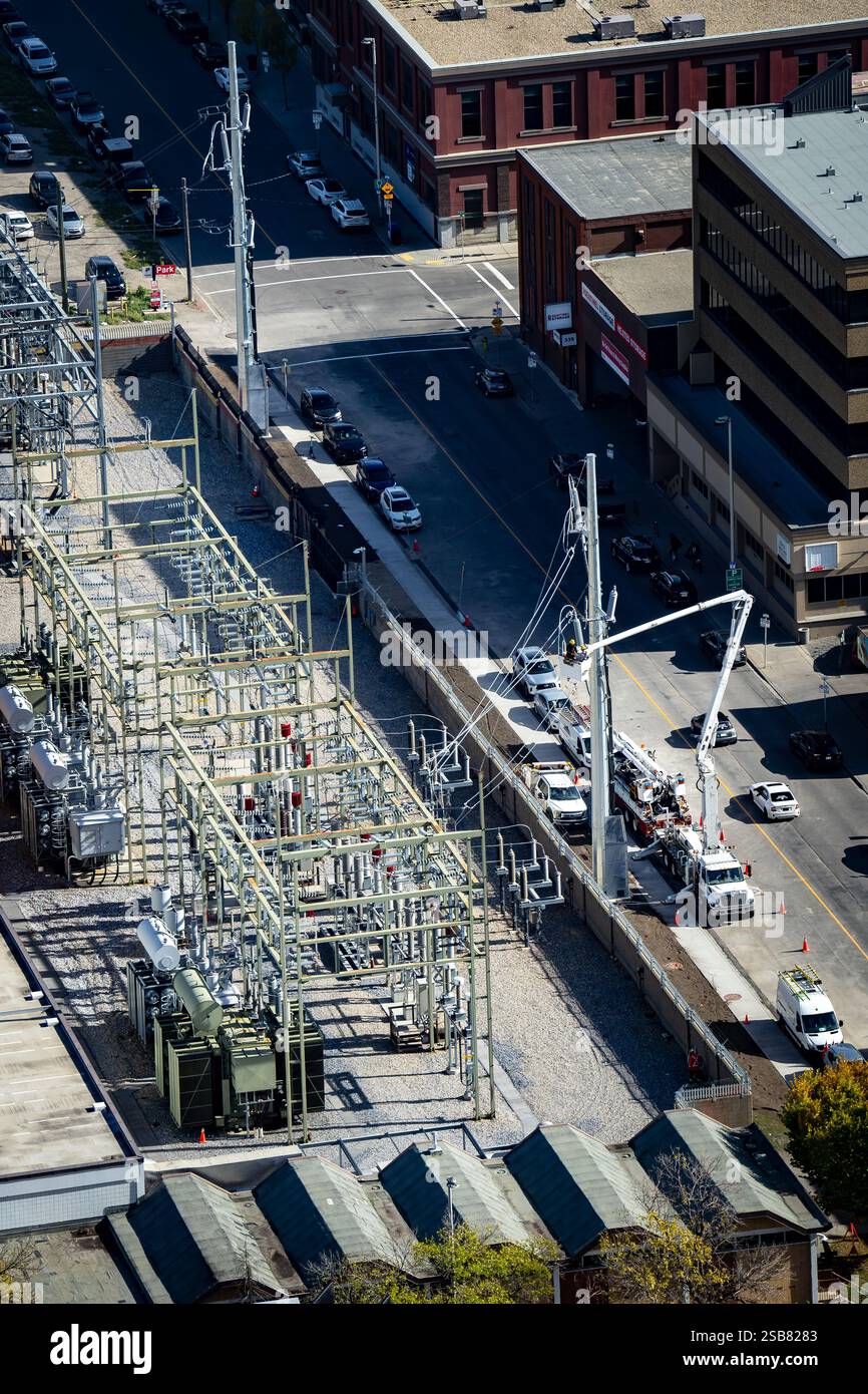 Calgary Alberta Canada, octobre 30 2024 : équipes de services publics dans des camions à godets travaillant sur les lignes électriques et le réseau électrique dans les rues du centre-ville. Banque D'Images