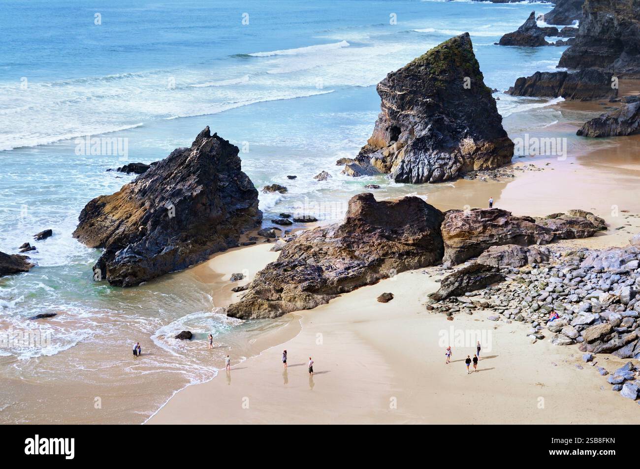 Les gens sur la plage à Bedruthan Steps avec les empilements de rochers géants le long de la côte cornouillère spectaculaire, Cornwall, Angleterre, Royaume-Uni. plages côtières Banque D'Images