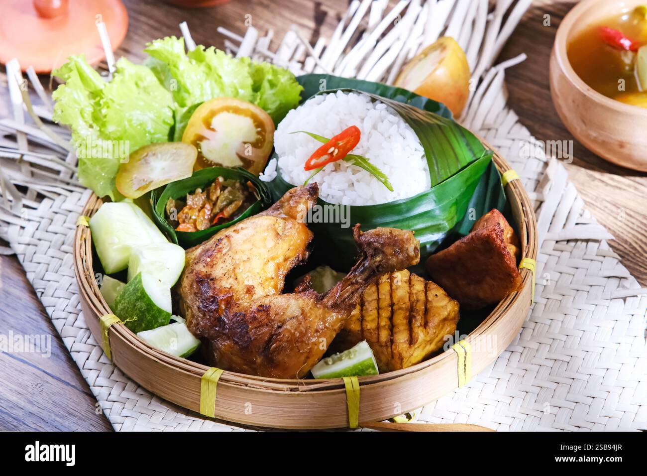 Nasi Ayam Bakar, poulet rôti avec tempeh, pâte de piment et légumes. Cuisine indonésienne Banque D'Images
