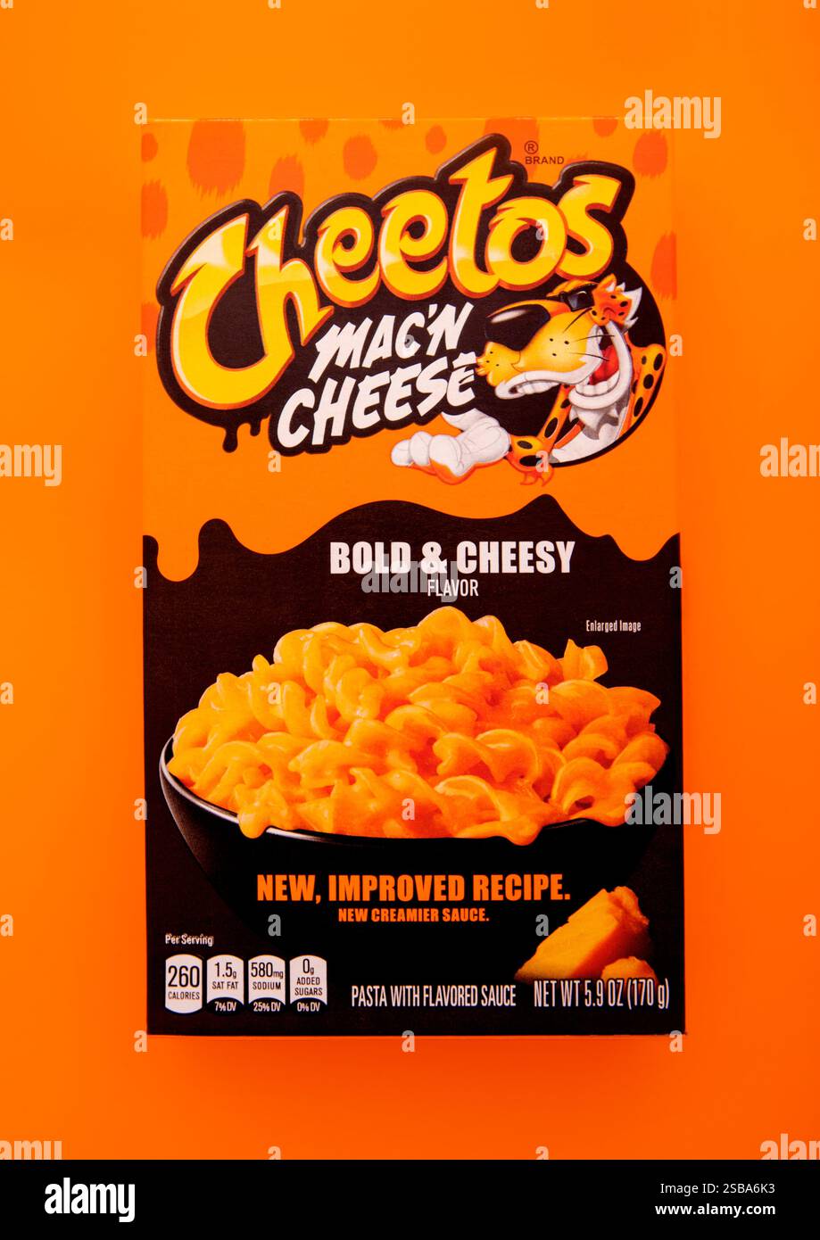 LONDRES, Royaume-Uni - 30 DÉCEMBRE 2024 : boîte de Cheetos mac'n et fromage gras et pâtes au fromage sur fond orange. Banque D'Images
