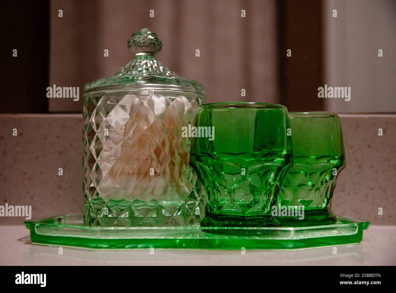 Deux verres à boire verts et boîte sur le comptoir de la salle de bain Banque D'Images