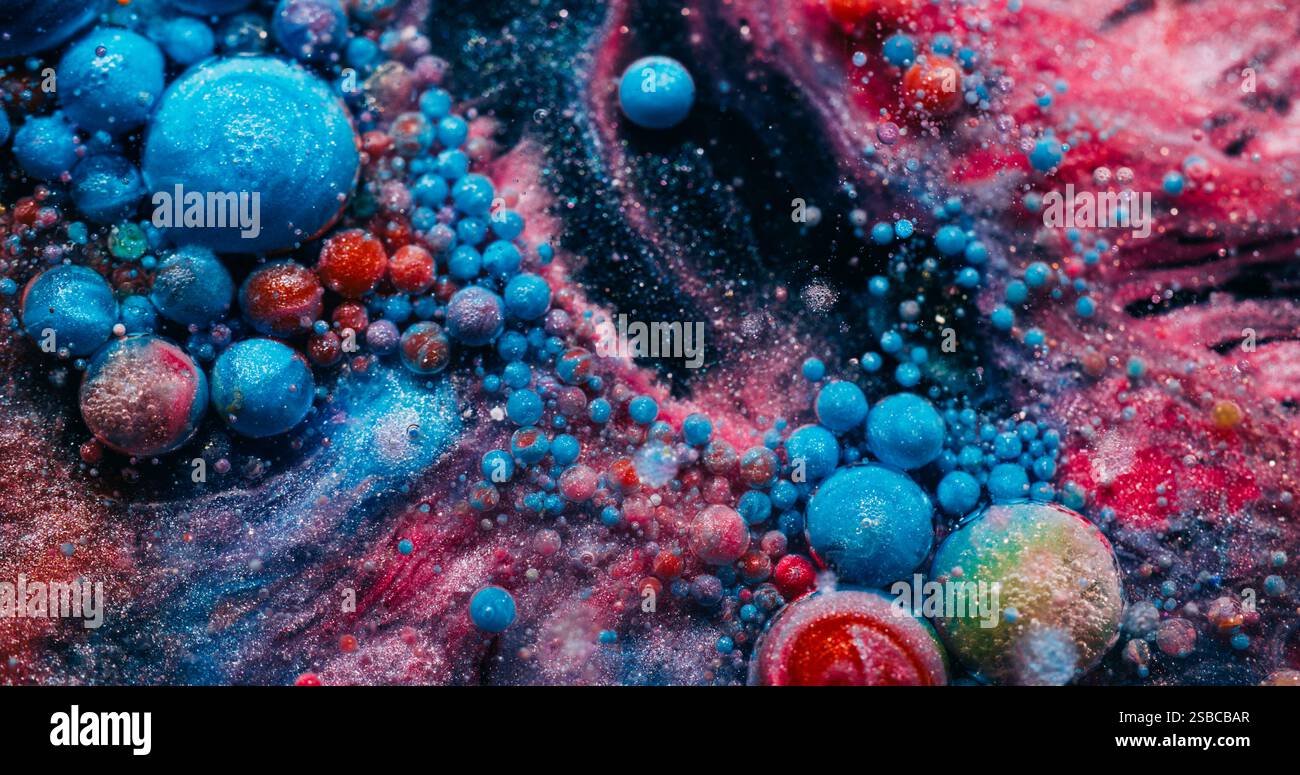 Fizz coloré. Peinture savonneuse. Bulles rondes roses bleues en mousse flottant dans une eau sombre chatoyante. Fond abstrait de particules liquides créatives. Banque D'Images