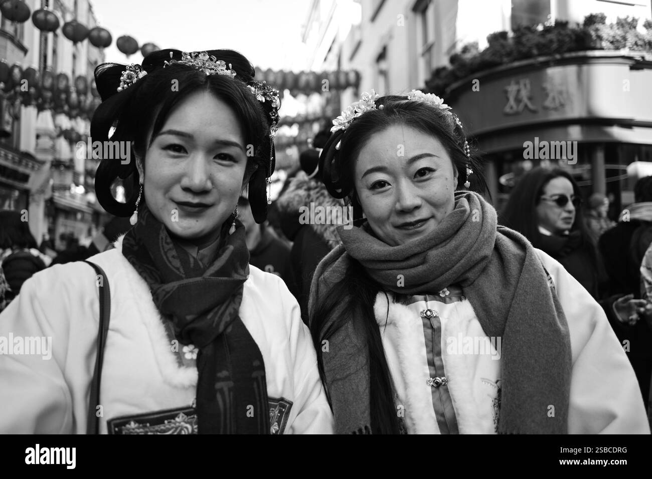 Des femmes en tenue traditionnelle échangent des articles pendant les célébrations du nouvel an chinois à Londres Banque D'Images