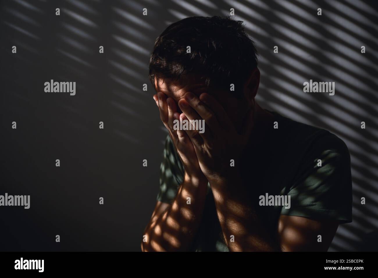 Concept de mois de sensibilisation à la santé mentale, image basse clé d'un homme adulte pleurant dans une pièce sombre, foyer sélectif Banque D'Images