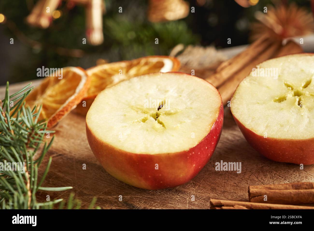 Pomme coupée en deux avec une étoile au milieu, avec cannelle, branches d'épicéa et décoration de Noël Banque D'Images