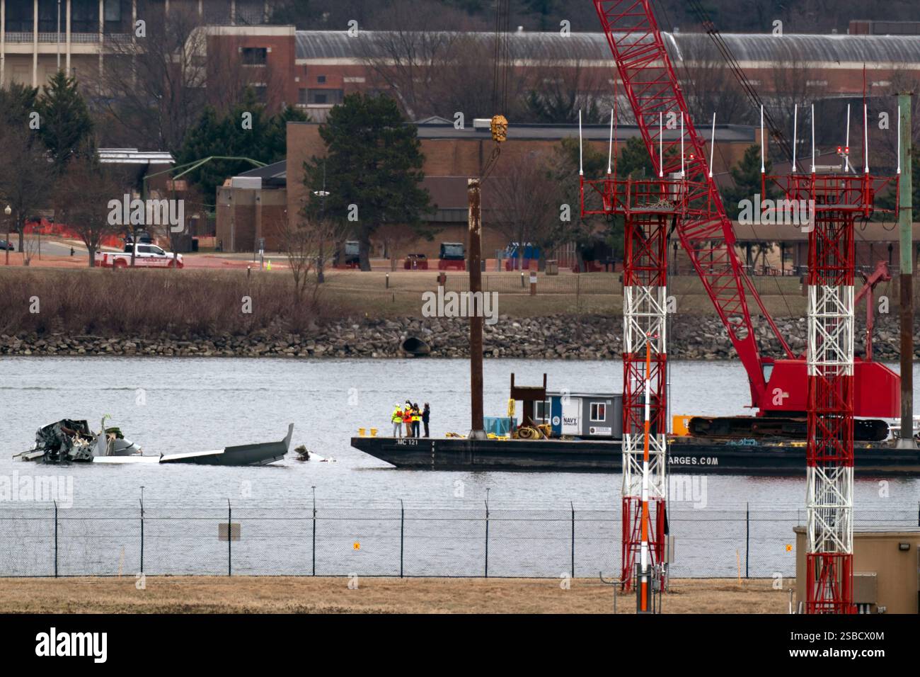 Rescue and salvage crews with cranes work near the wreckage of an ...