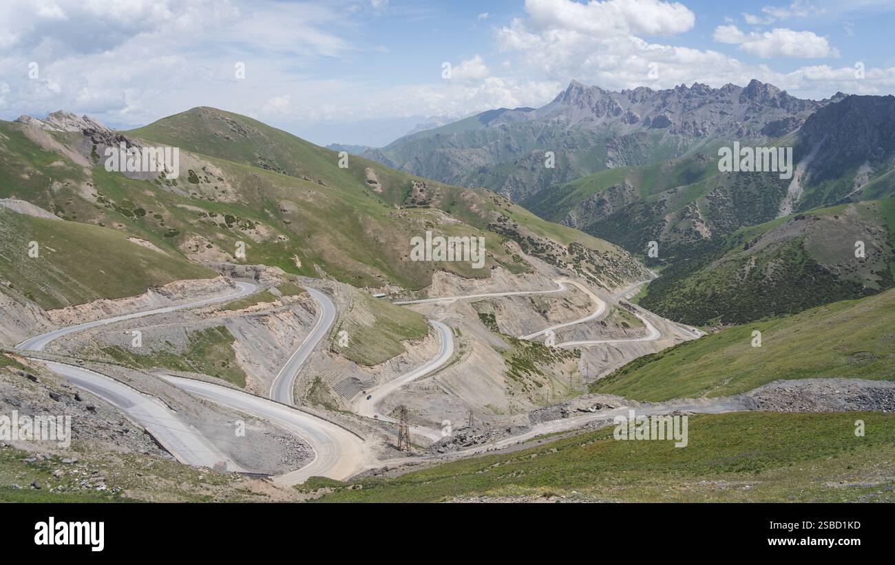 Route asphaltée de montagne courbant à travers le col alpin avec de grands sommets de la chaîne de Tien shan, Kirghizistan Banque D'Images