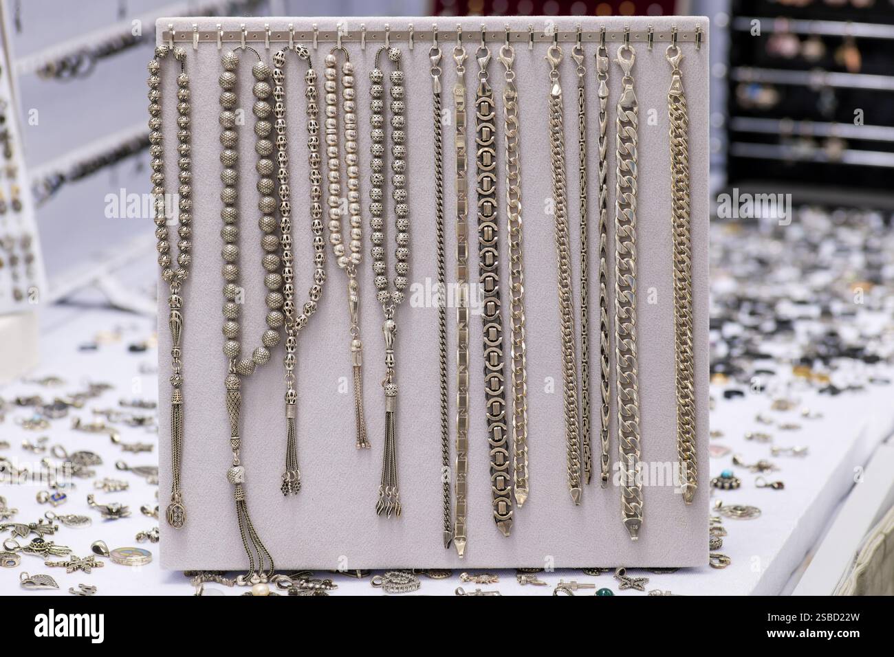 Une collection de bracelets en argent et de perles de prière élaborées élégamment exposées sur un stand de bijoux, mettant en valeur l'artisanat et les détails m Banque D'Images