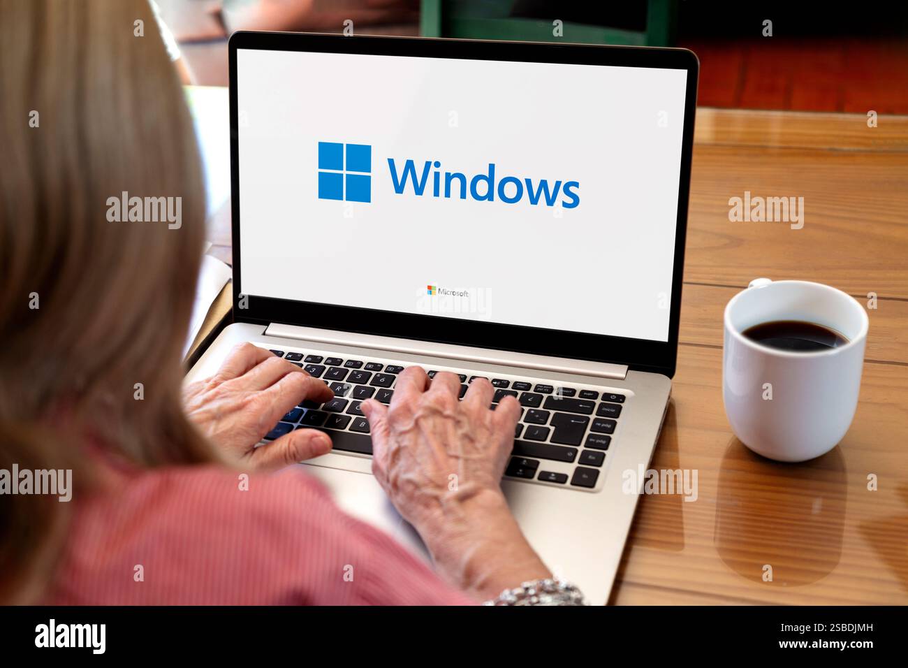 Windows sur l'écran de l'ordinateur portable. Femme utilisant le système d'exploitation le plus populaire de Microsoft. Rosario, Argentine - 01 février 2025. Banque D'Images