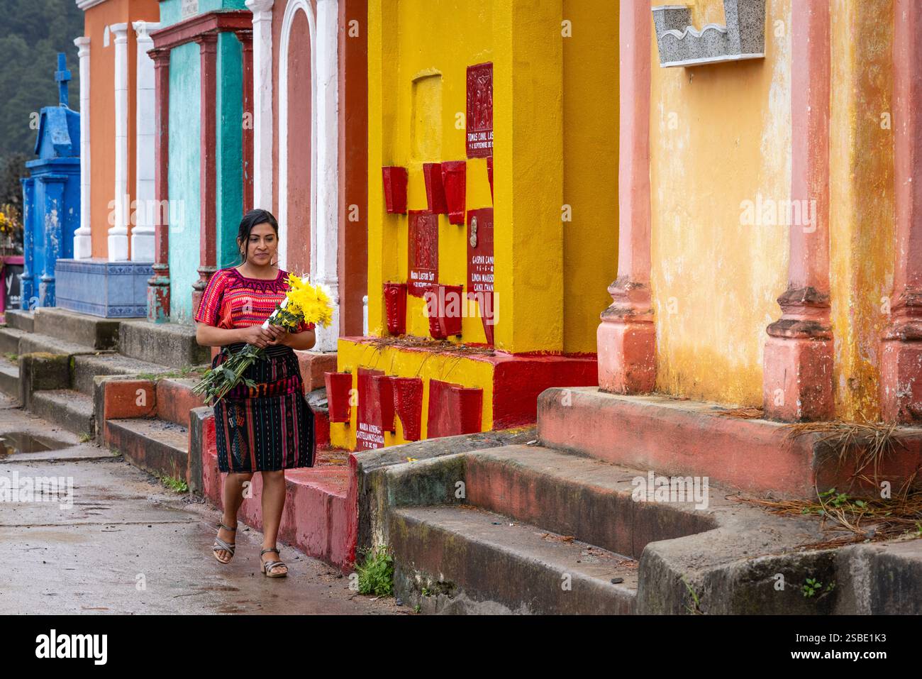 Femme portant des offrandes de fleurs au cimetière maya de Chichicastenango, au Guatemala Banque D'Images