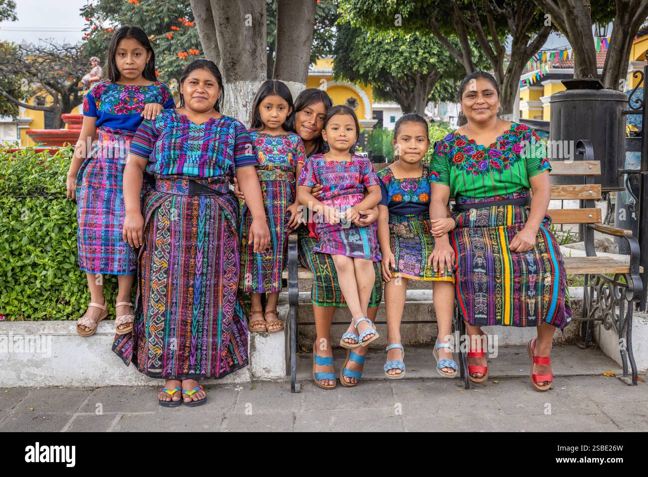 Famille guatémaltèque ensemble sur le banc du parc à San Antonio Aguas Calientes, Guatemala Banque D'Images