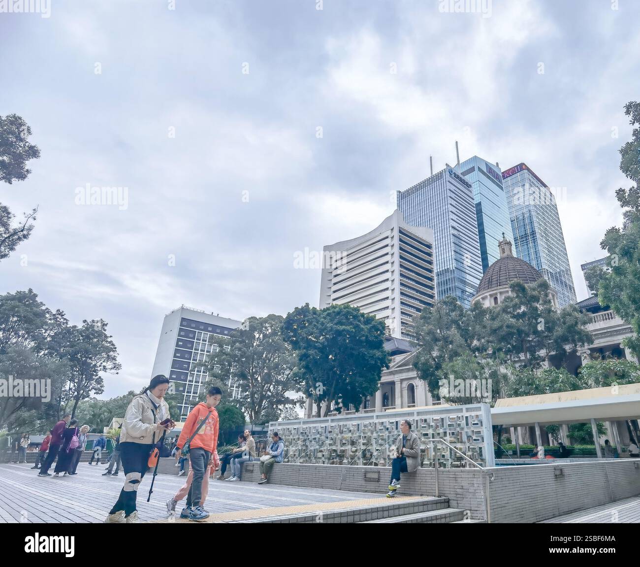 Hong Kong, Chine - 01 février 2025 : vue rapprochée du quartier central des affaires de Hong Kong. Les voyageurs et les habitants se promènent au milieu d'un gratte-ciel moderne Banque D'Images
