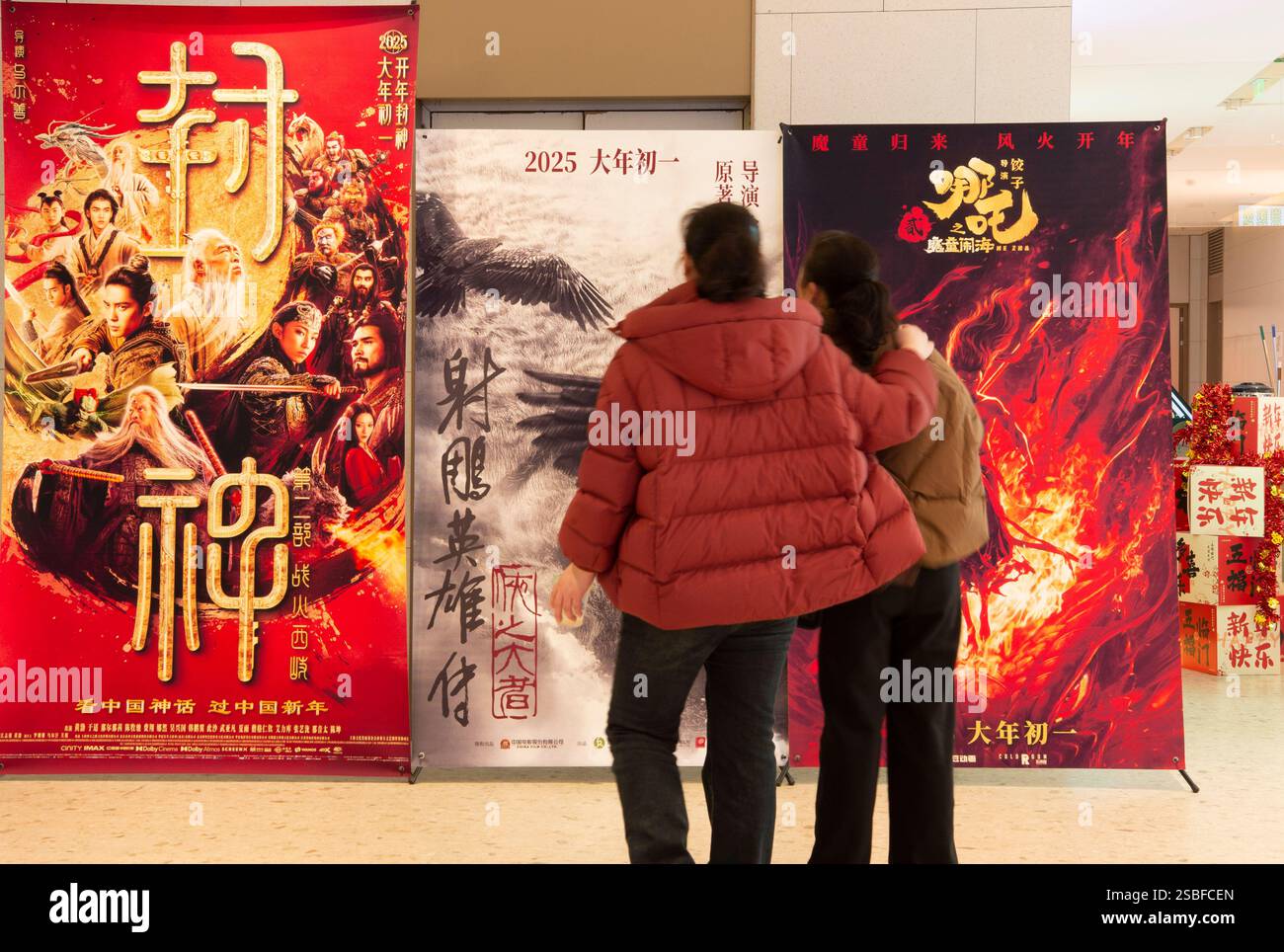 HAI'AN, CHINE - 3 FÉVRIER 2025 - les visiteurs regardent une affiche de film du nouvel an chinois à l'entrée d'un cinéma à Hai 'an, Jiangsu pr Banque D'Images