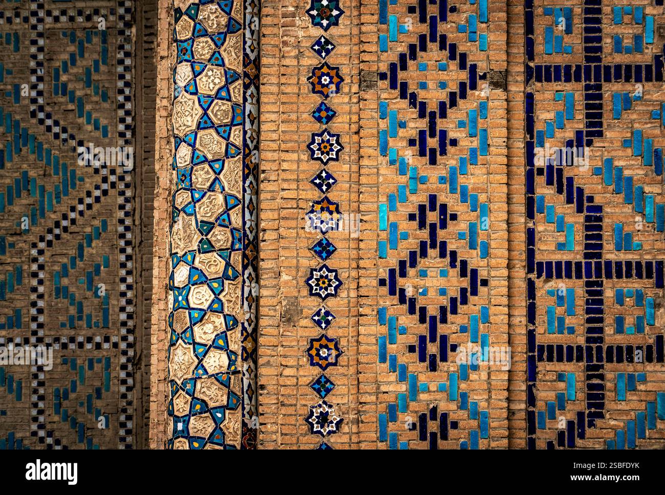 Carrelage complexe avec des motifs géométriques en bleu et blanc sur un fond de briques texturées. Banque D'Images