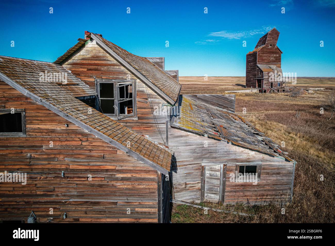 Une maison avec un toit et une grange en arrière-plan. La grange est vieille et a une grande structure en pierre Banque D'Images