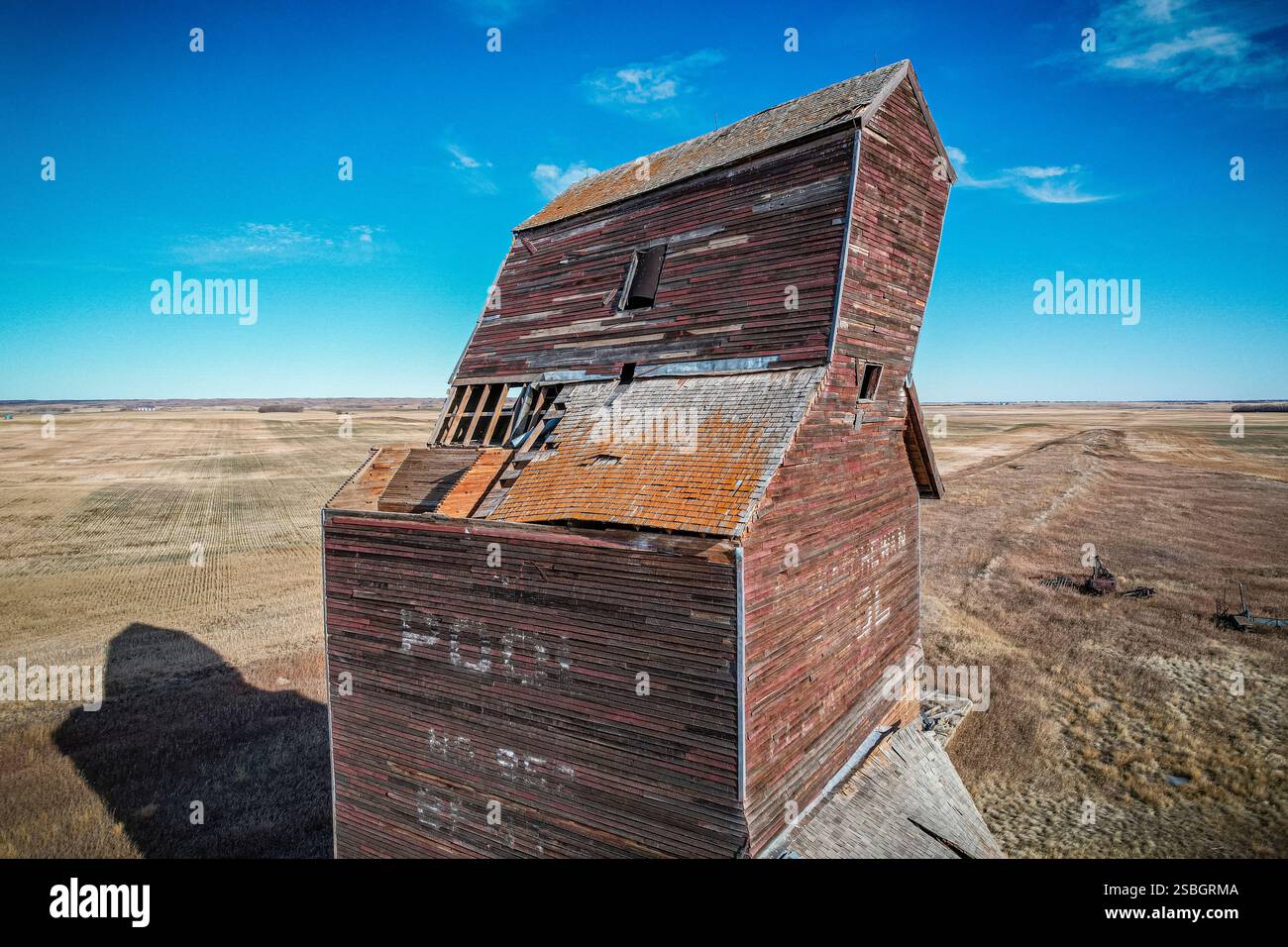 Un grand, vieux, bâtiment rouge avec beaucoup de dégâts. Le toit est manquant et le bâtiment est penché Banque D'Images