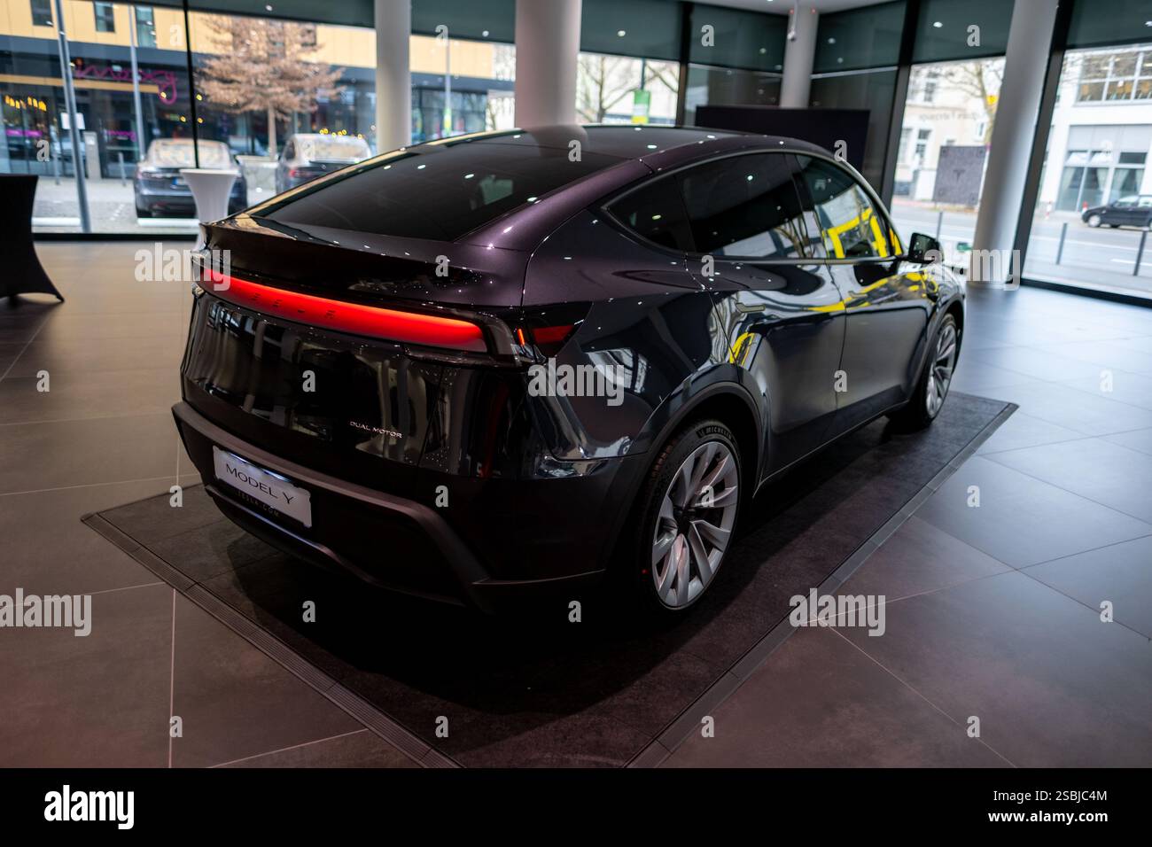Nouveau Tesla car Model y Juniper 2025 en Studio, noir véhicule électrique métallique dans la salle d'exposition, barre lumineuse arrière, concept de développement d'énergie alternative, Elo Banque D'Images